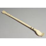 A 19TH CENTURY EUROPEAN IVORY CARVED BACK SCRATCHER, one end with a hand, the other bobbin type