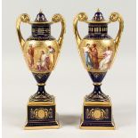 A VERY GOOD PAIR OF 19TH CENTURY VIENNA PORCELAIN TWO HANDLED URNS AND COVERS painted with classical