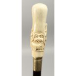 A CARVED BONE HANDLED WALKING STICK. Elongated Chinese man's head. 34ins long.