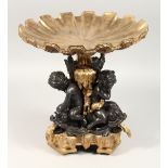 A GOOD BRONZE AND ONYX COMPORT as three cupids holding a shell, 12ins high.