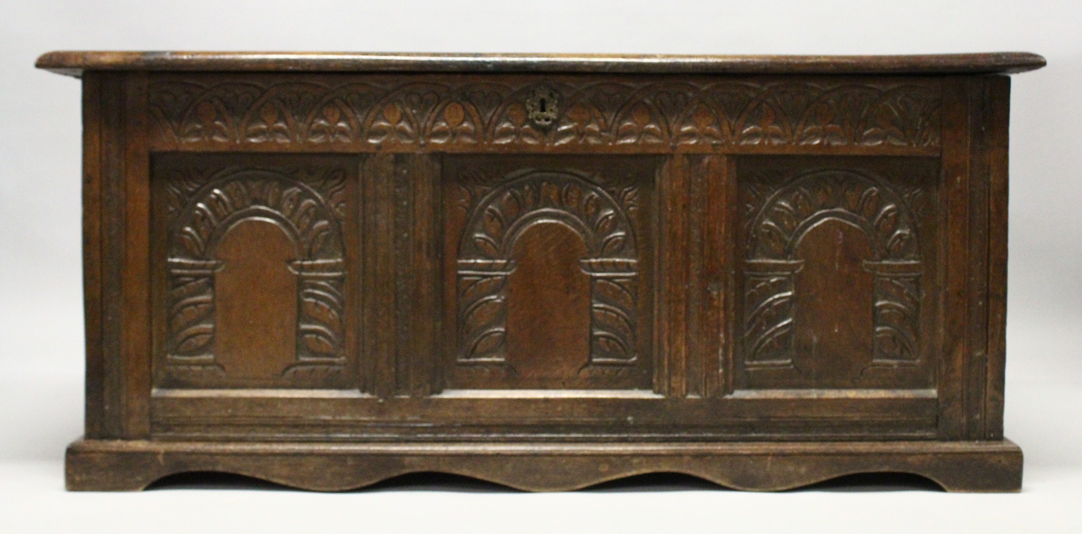 AN 18TH CENTURY OAK COFFER with a panelled top and triple panelled front, carved with arches. 4ft - Image 2 of 4