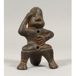 A SOUTH AMERICAN POTTERY WHISTLE as a seated figure,possibly from Peru. 4ins.