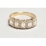 AN 18CT. YELLOW GOLD EMERALD CUT DIAMOND HALF HOOP RING