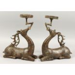 A PAIR OF CHINESE BRONZE DEER STICKS, 13ins high.