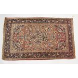 A PERSIAN RUG, MID 20TH CENTURY, pink ground with all over floral decoration. 7ft 2ins x 4ft 3ins.