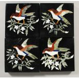 A SET OF FOUR BLACK MARBLE TILES inlaid with birch and foliage. 4ins square.