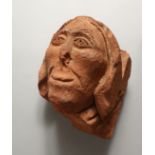 A 17TH CENTURY CARVED TERRACOTTA HEAD. 8.5ins high.
