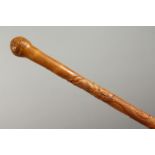 A JAPANESE ENGRAVED AND CARVED BAMBOO WALKING CANE, carved with an entwined dragon. 35ins long.