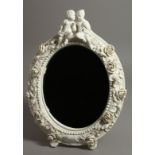 A DERBY WHITE GLAZED EASEL TYPE MIRROR FRAME, floral encrusted, with two children seated on top.