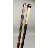 A HEAVY NATIVE WALKING CANE with stringing and carved shaft, 36ins long and a carved bamboo