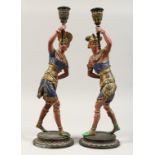 A PAIR OF 19TH CENTURY PAINTED SPELTER CANDLESTICKS "The AMERICAS" female figures on circular bases.