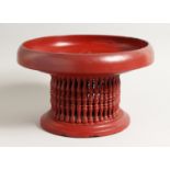 AN EASTERN WOODEN RED LAQUER CIRCULAR PAINTED TEMPLE STAND. 11.5ins diameter.