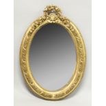 A SMALL GILT OVAL MIRROR 3ft high.