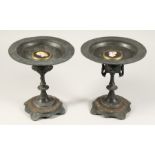 A PAIR OF EGYPTIAN REVIVAL METAL TAZZAS with circular top. 8.5ins high.