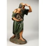A LARGE CARVED WOOD RELIGIOUS FIGURE carrying a cap. 24ins high.