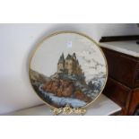 A GOOD LARGE METTLACH POTTERY CHARGER depicting a castle on a mountainous landscape.