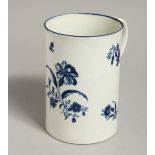 AN 18TH CENTURY TALL CYLINDRICAL MUG, decorated with a large blue flower, scattered floral sprigs