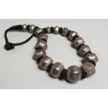 AN ISLAMIC SILVER AND BLACK BEAD NECKLACE.