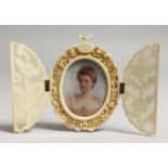 AN EDWARDIAN OVAL PORTRAIT MINIATURE OF A YOUNG LADY, bust length, housed in a pierced ivory