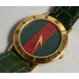 A GUCCI RED FACE WRIST WATCH with leather strap.