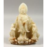 A CHINESE CARVED WHITE JADE GUANYLIN GROUP, 11ins high