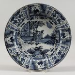 AN 18TH CENTURY DUTCH DELFT TIN GLAZED CIRCULAR DISH, painted with figures in a landscape in the