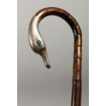 A BAMBOO TYPE WALKING STICK with silver duck's head handle and glass eyes. August 1911.
