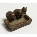 THREE JAPANESE BRONZE PIGS IN A TROUGH.