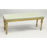 A LONG 19TH CENTURY GILTWOOD FRENCH STOOL with padded top on fluted legs. 3ft 10ins long, 1ft 3ins