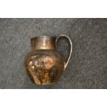 A hammered silver cream jug.