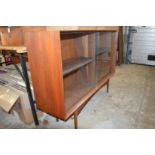 A mid-century hardwood bookcase with sliding doors.