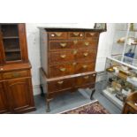 An 18th century walnut and feather banded chest on stand with three frieze drawers, three long