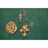 A decorative gilt metal brooch and other items.