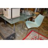 A frosted glass and chrome framed dining table with five designer chairs.