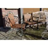 A pair of wrought iron and rattan garden armchairs.