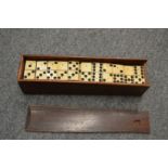 An old mahogany box of bone and ebony dominoes.