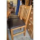 A pair of modern oak dining chairs.