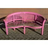A pink painted hardwood garden bench.