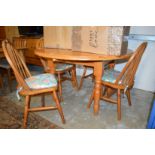 A modern pine drop flap kitchen table and four chairs.