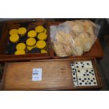 A set of ebony and bone dominoes, a bag of counters and a box containing draught counters.