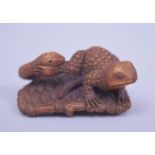 A JAPANESE MEIJI PERIOD CARVED BOXWOOD NETSUKE - TOAD AND SERPENT, the toad upon a sandle being