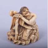 A JAPANESE MEIJI PERIOD CARVED IVORY NETSUKE - SEATED SENNIN, the sennin leaning upon his staff with