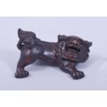 A SMALL CARVED WOOD FIGURE OF A LION DOG, 5.5cm wide.