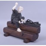 A JAPANESE MEIJI PERIOD MIXED MEDIA OKIMONO - WOODWORKER, the man formed from bronze and ivory