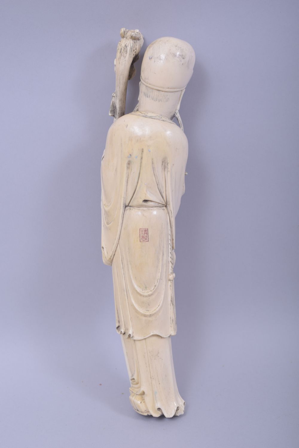 A CHINESE CARVED IVORY FIGURE OF A SAGE, holding a dragon staff, red seal to reverse, 30cm high. - Image 2 of 5