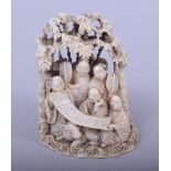 A JAPANESE MEIJI PERIOD CARVED IVORY OKIMONO - NINE IMMORTALS under bamboo trees holding a scroll