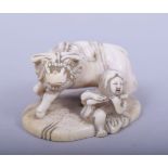A JAPANESE MEIJI PERIOD CARVED IVORY NETSUKE - OXEN AND FEMALE, the female figure seated aside an