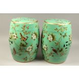 A PAIR OF CHINESE GREEN PORCELAIN BARREL SEATS, flowers and birds. 18ins high.