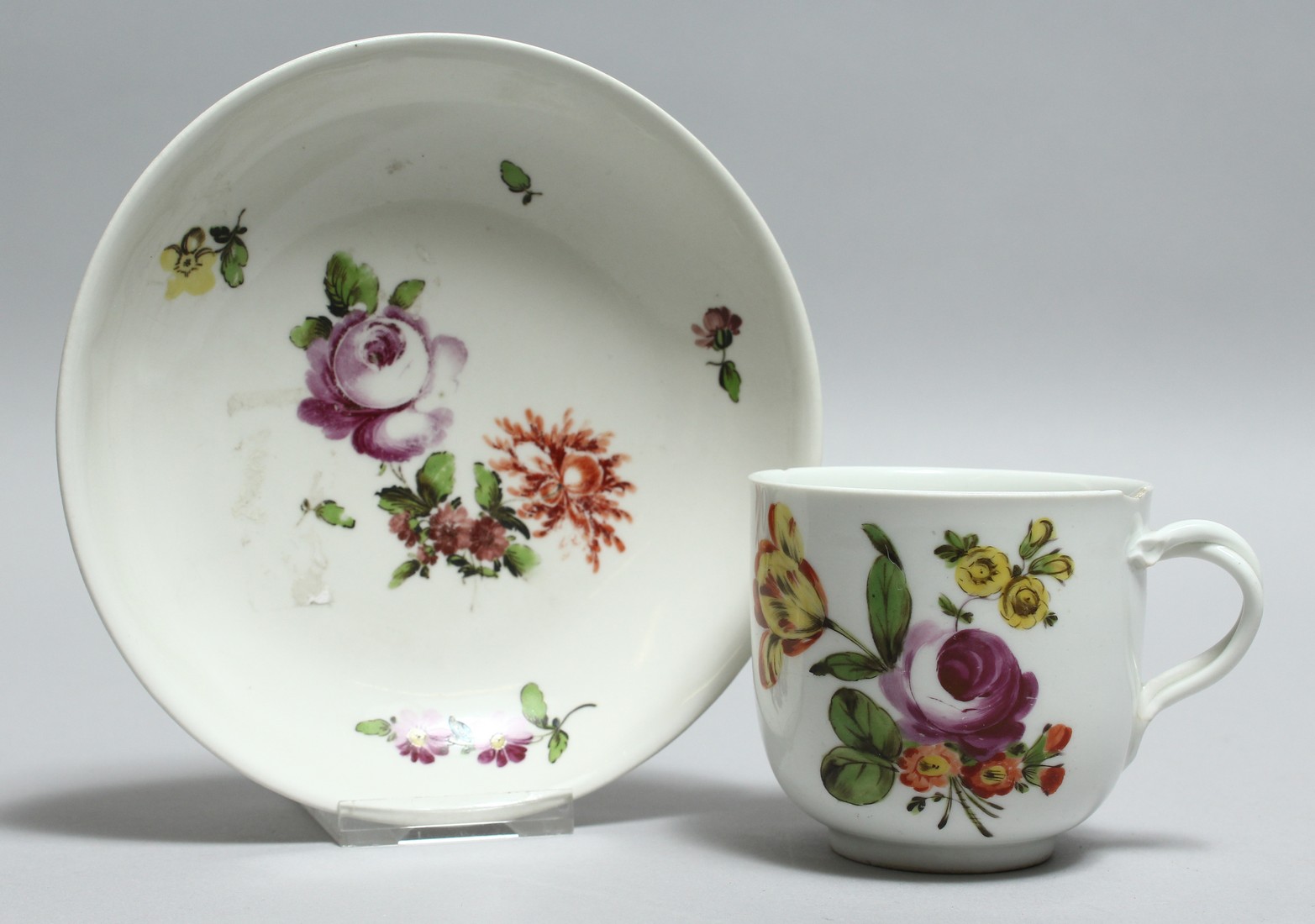 A 19TH CENTURY VIENNA PORCELAIN CUP AND SAUCER painted with flowers. Bee hive mark in blue