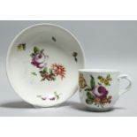 A 19TH CENTURY VIENNA PORCELAIN CUP AND SAUCER painted with flowers. Bee hive mark in blue